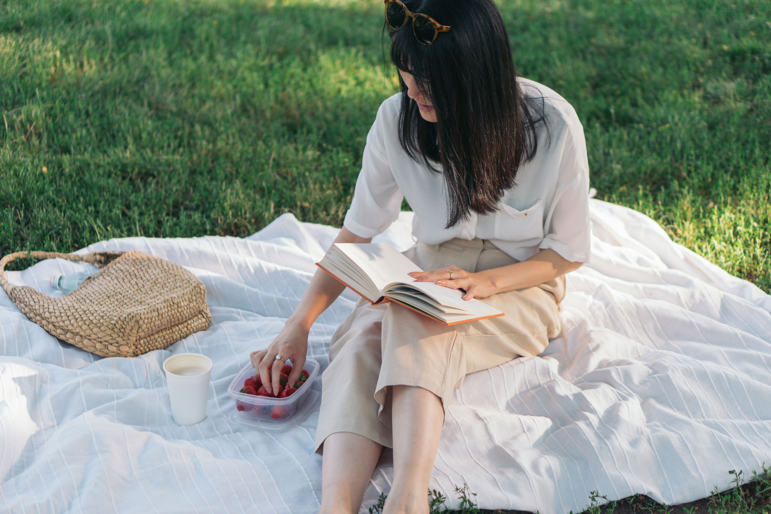 Woman picnicking with strawberries at park