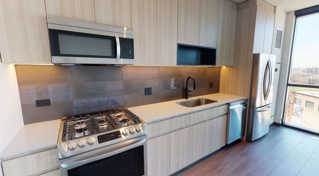 ceramic tile backsplash, white quartz countertops, and stainless steel appliances in a luxury kitchen at Parq Fulton