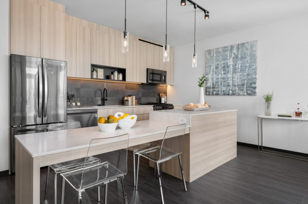 luxury apartment kitchen with stainless steel appliances, custom built-in island extensions, and quartz countertops